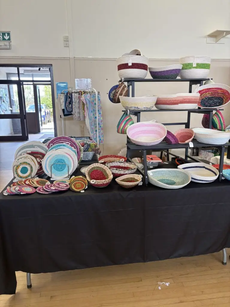 A craft fair table full of fabric rope bowls and coasters