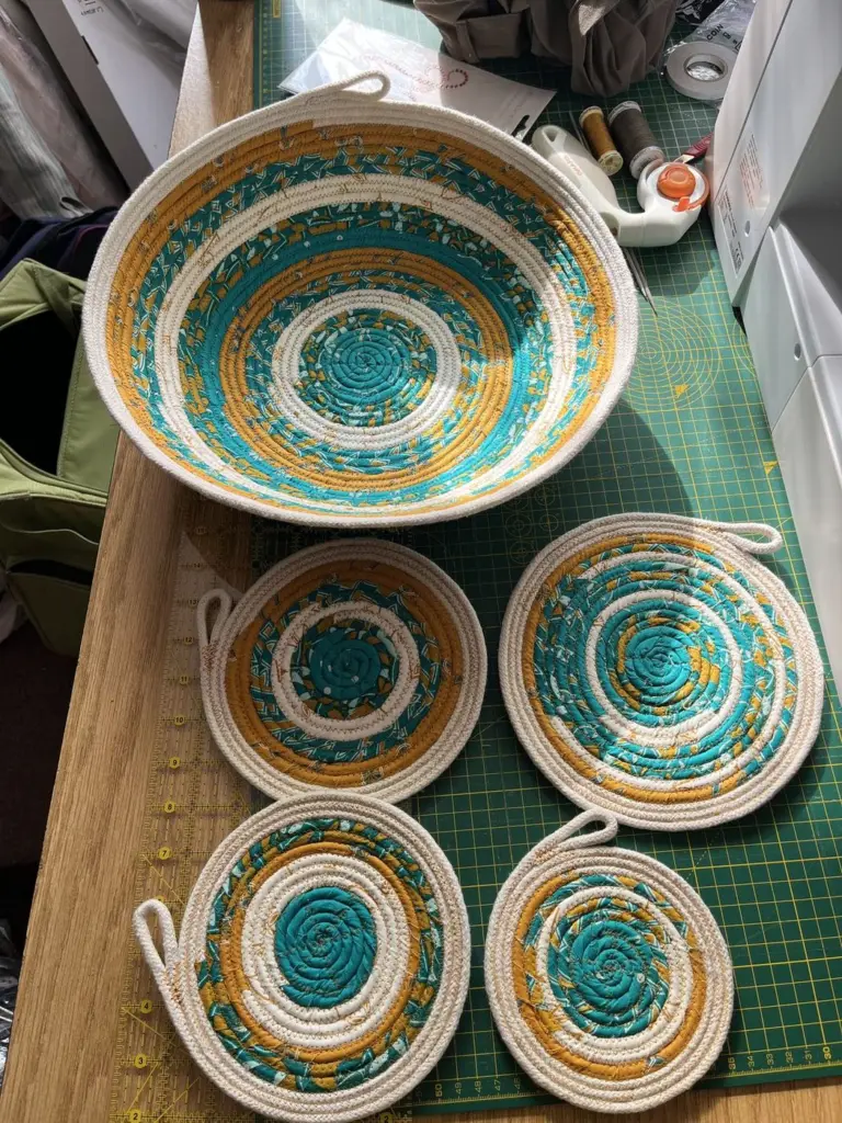 A turquoise and mustard fabric rope bowl with four matching coasters