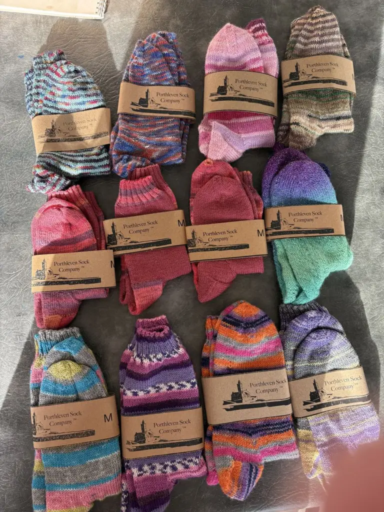 A collection of hand knitted socks in bright self-striping yarns