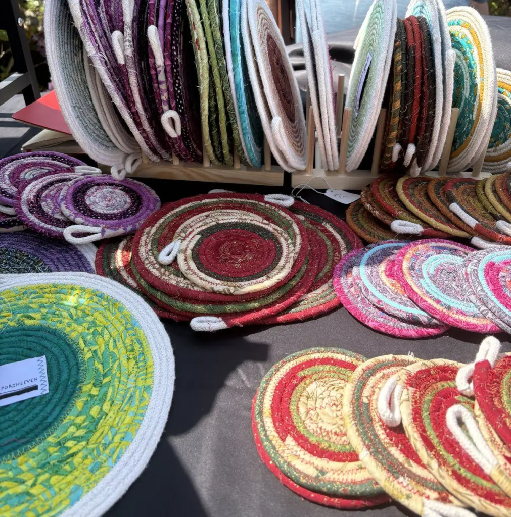 Rows of fabric rope coasters and trivets on a market stall
